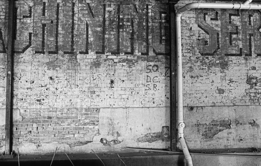 An old brick wall with a visible ghost sign.