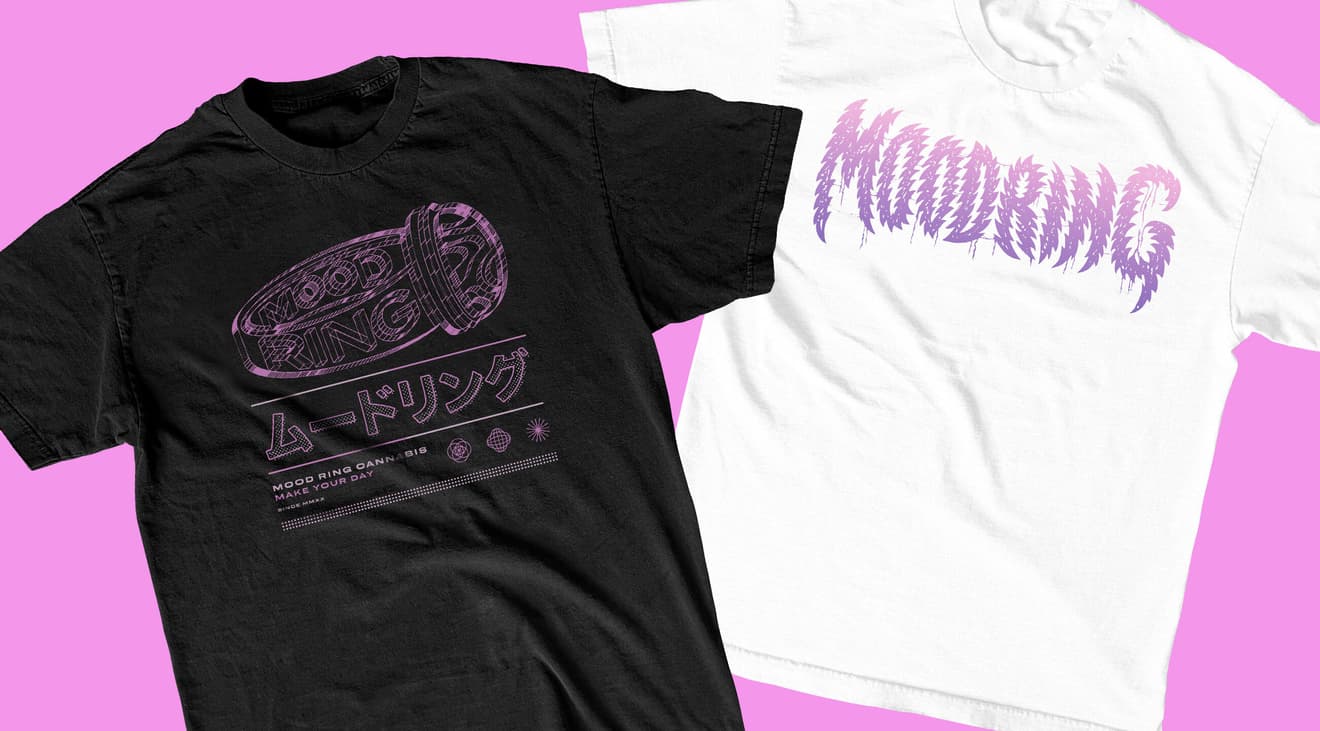 A black graphic tee and a white graphic tee on a pink background.