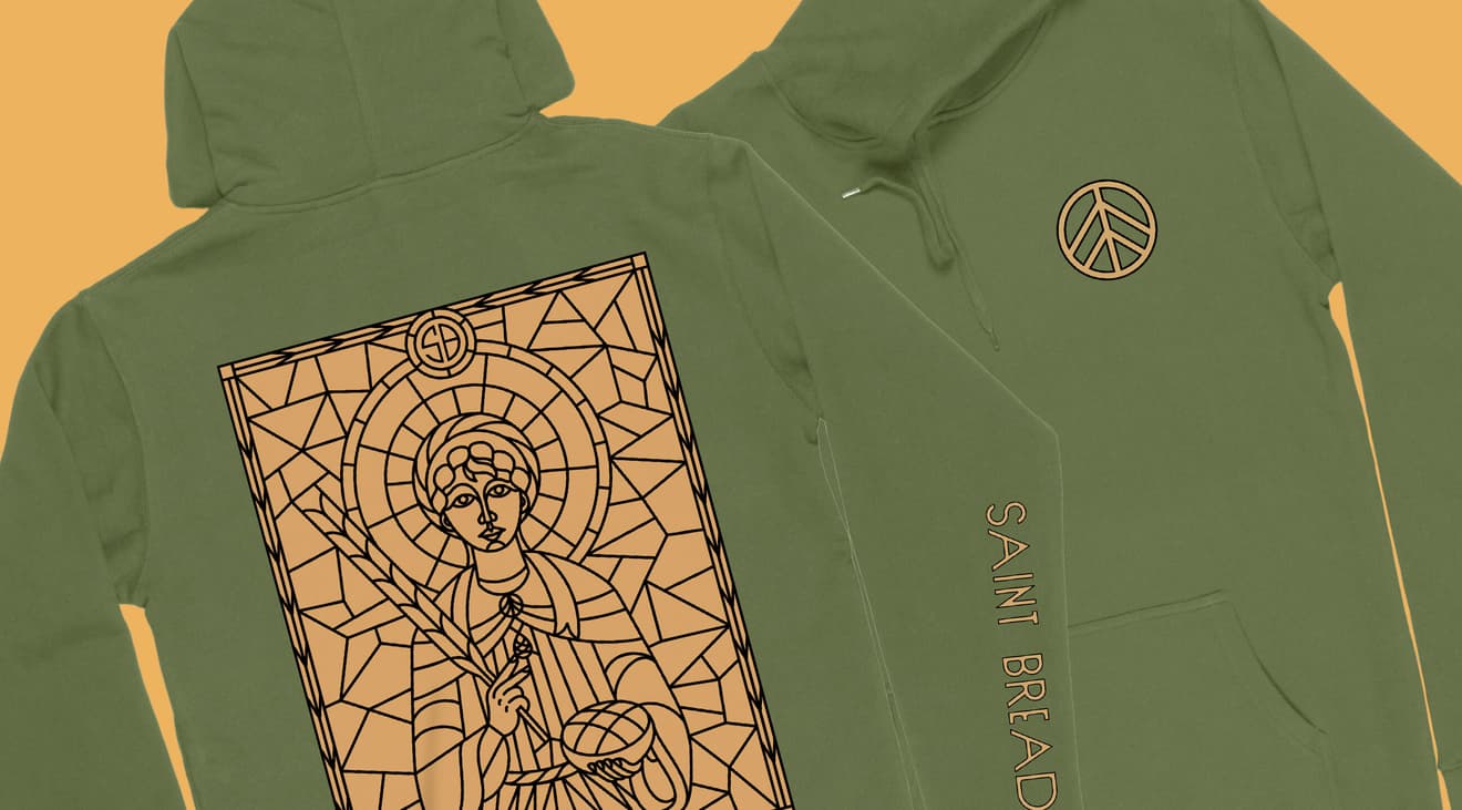 A green hoodie on a yellow background with the saint graphic on the back and the wheat logo on the front.