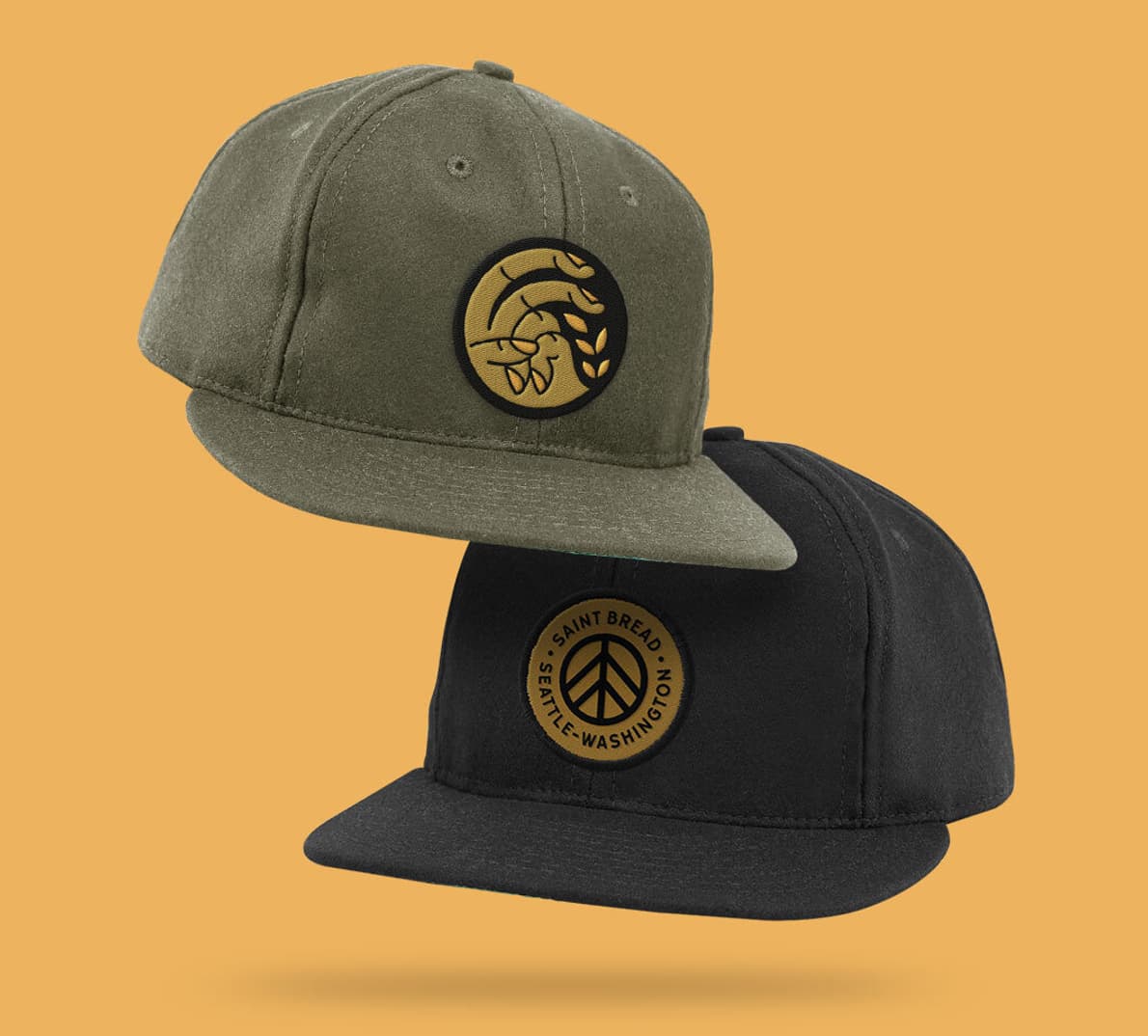 A black and a green Saint Bread hat on a yellow background.