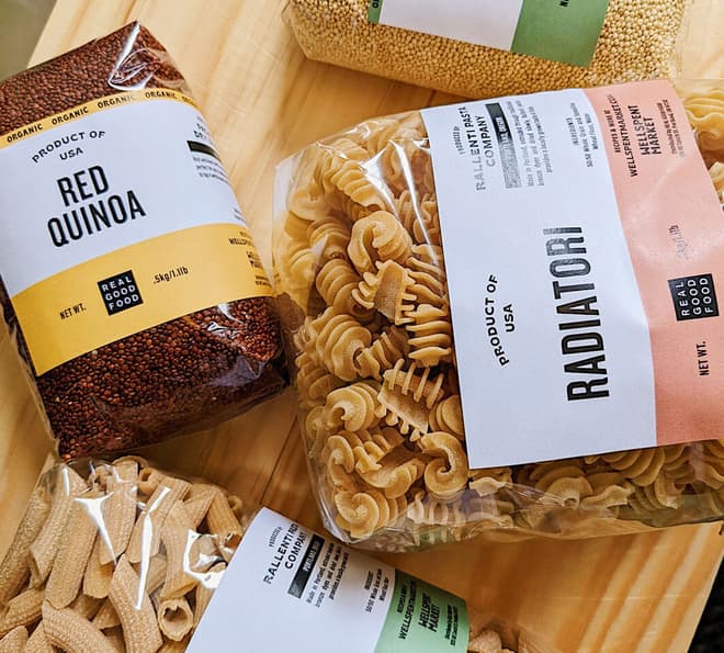 Various products like pasta and red quinoa are laid out next to each other. 