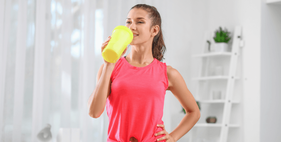 a woman drinking a protein drink