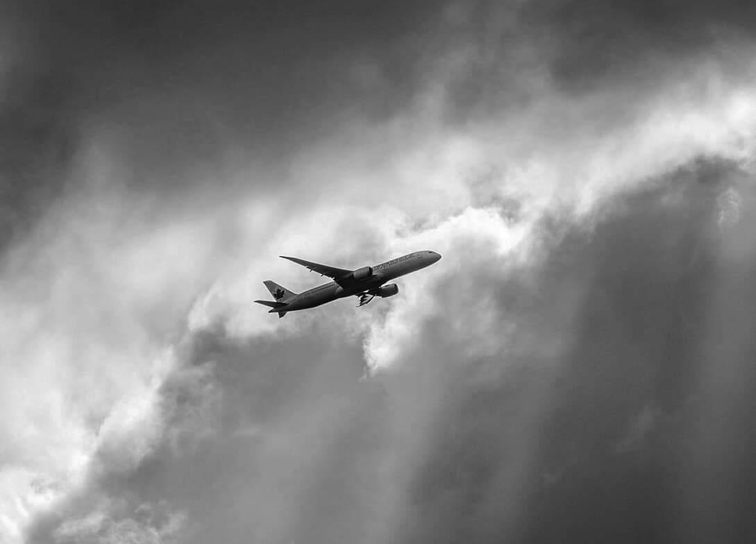 Airplane flying through grey and stormy clouds