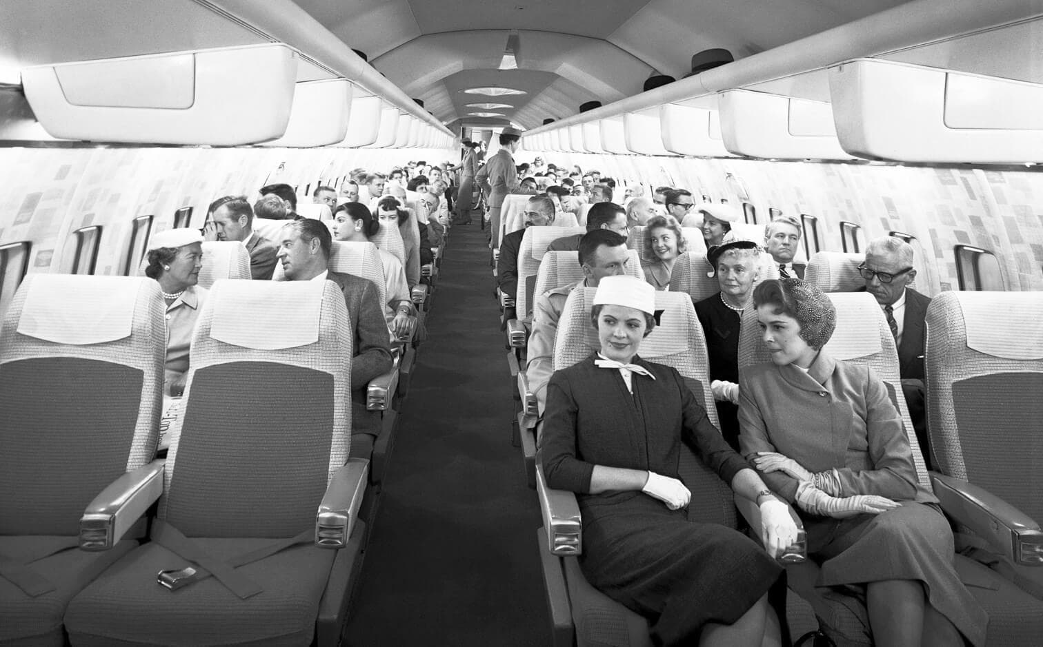 Group of women and men sitting in Boeing 707 mockup