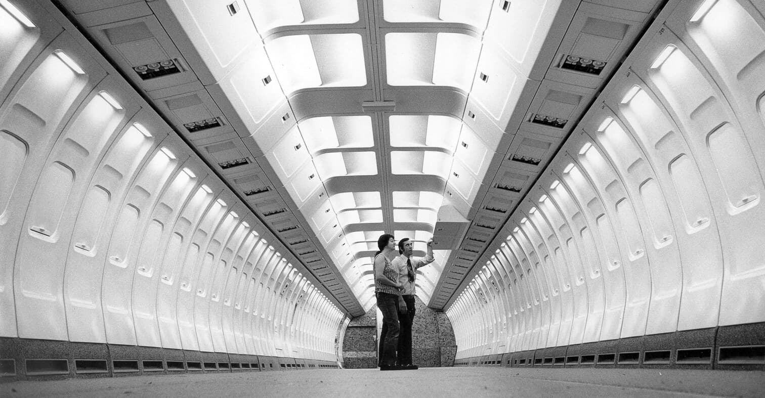 Two designers standing in empty 727 airplane mock up