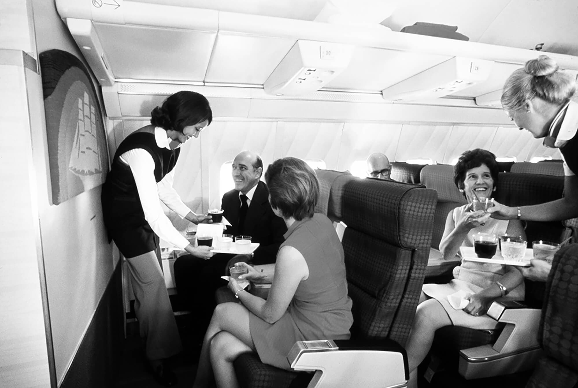 Passengers joyfully receiving meal service on a Pan Am flight