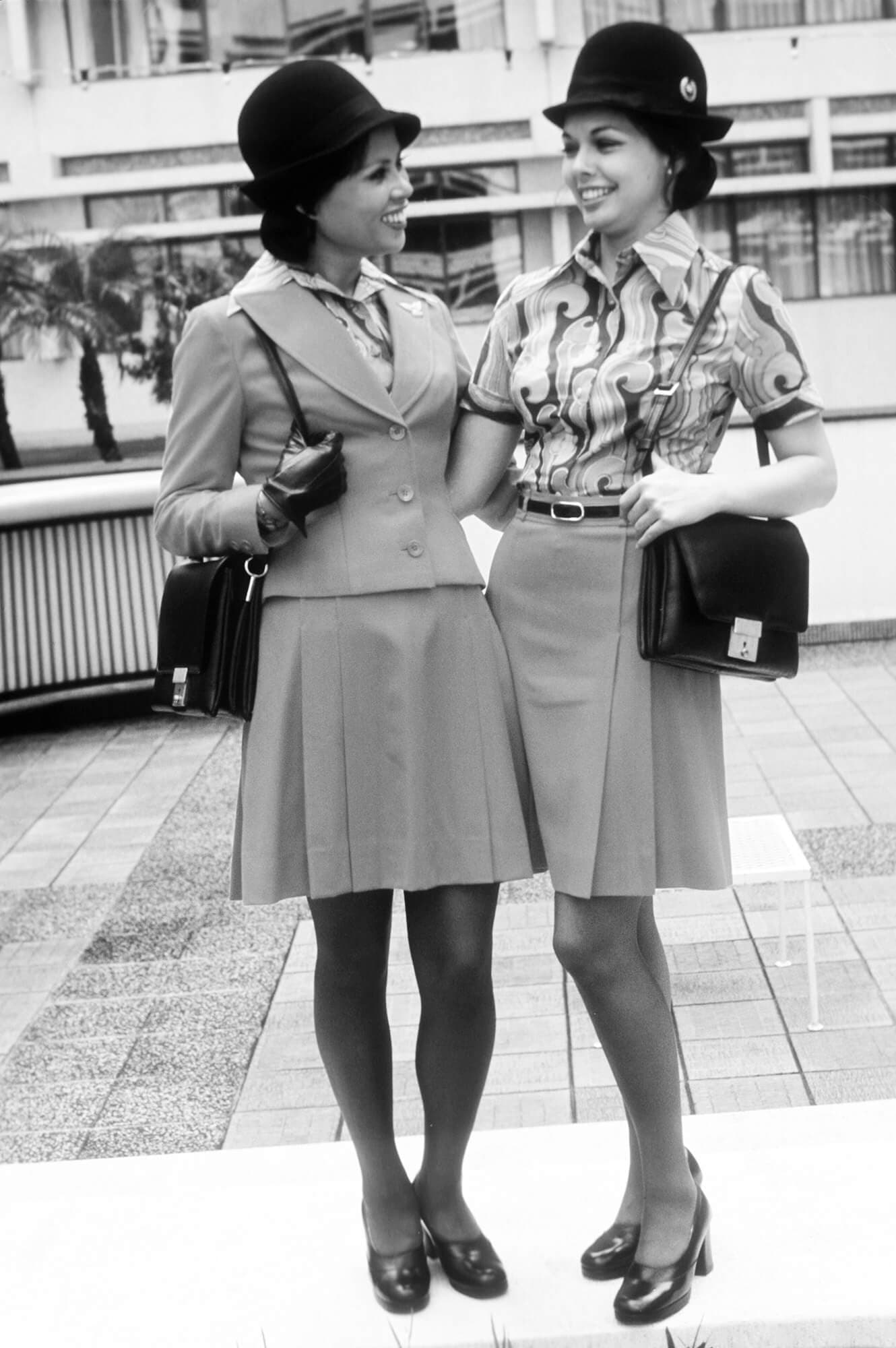 Two flight attendants posing in uniforms design by Teague