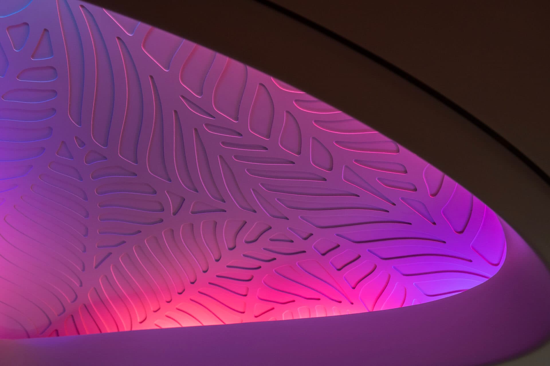 Ceiling dome detail on Hawaiian Airlines 787 with magenta and blue lighting directed across leaf pattern