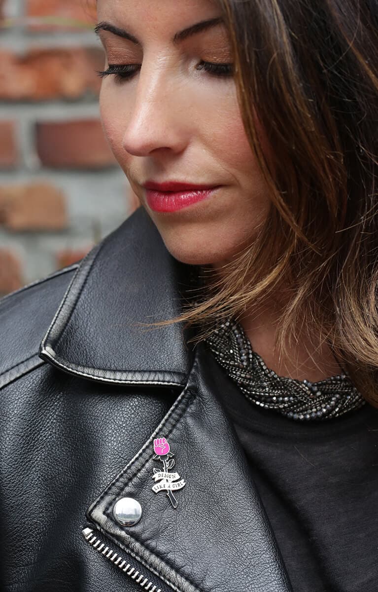 Women in leather jacketed wearing "design like a girl" pin