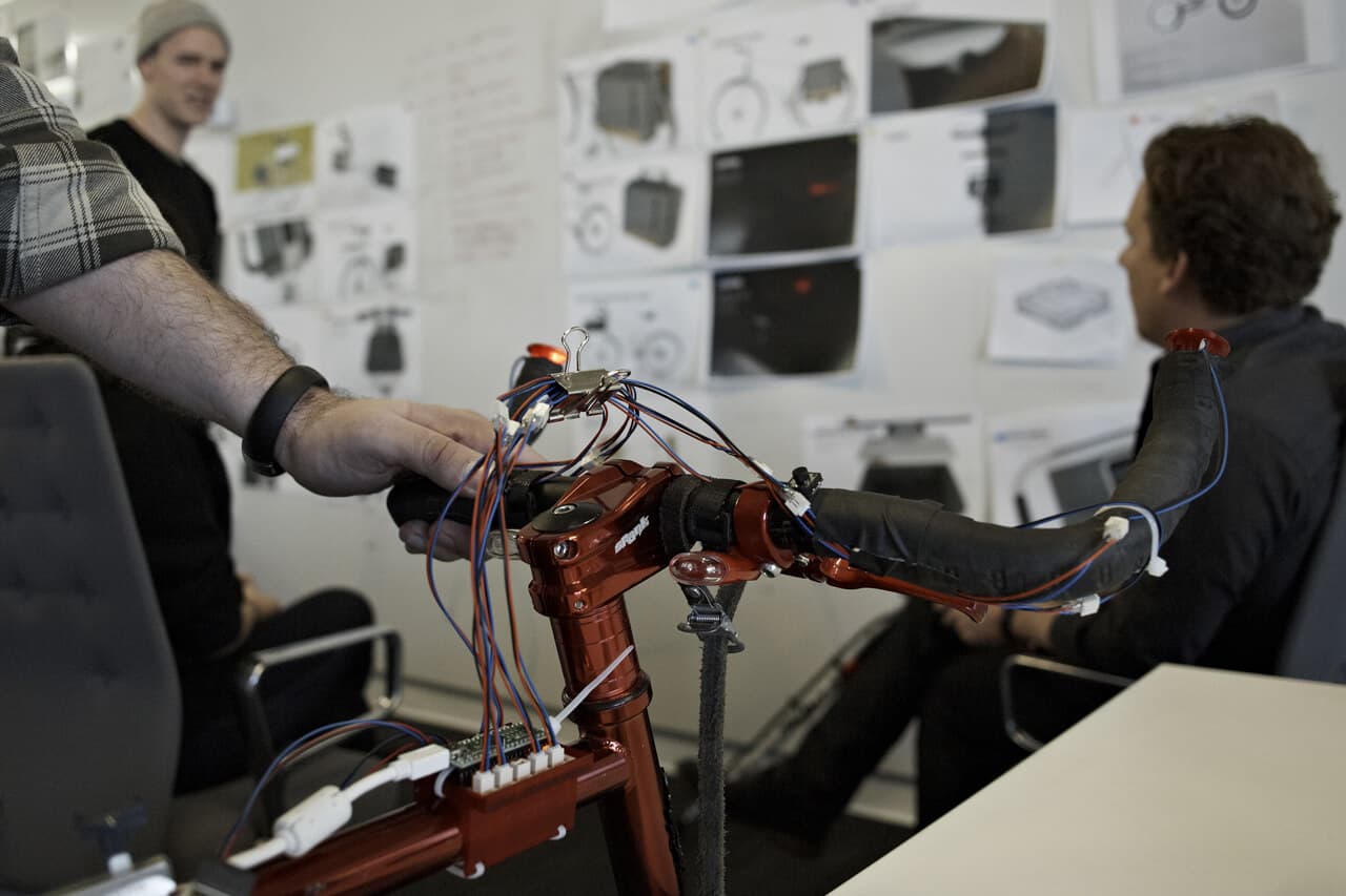 Denny bike design team reviewing electrical components mounted to bike prototype