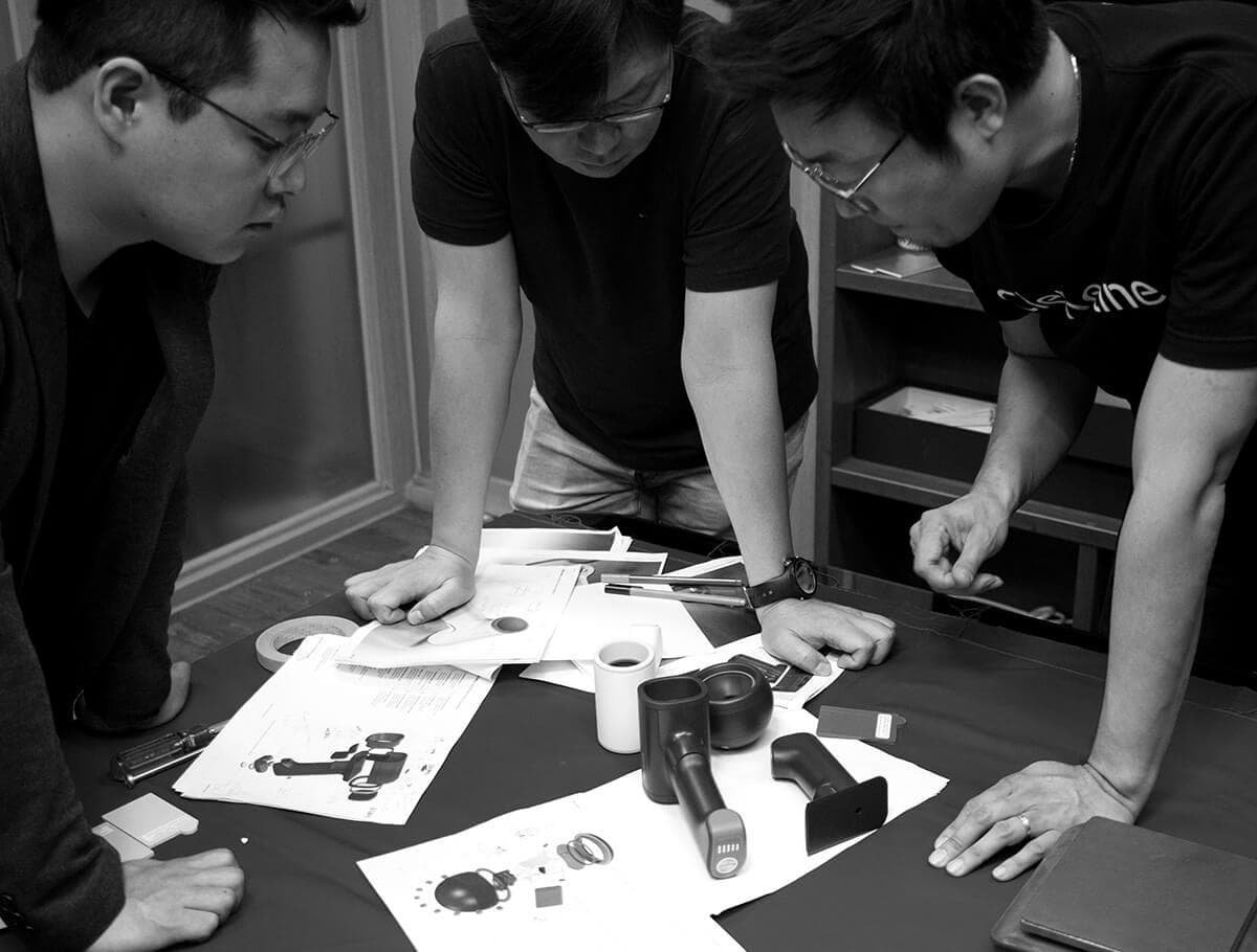 Group of men reviewing design sketches and 3D printed parts