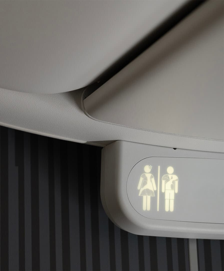 Hawaiian Airlines 787 bathroom signage with gender symbols wearing Hawaiian clothing