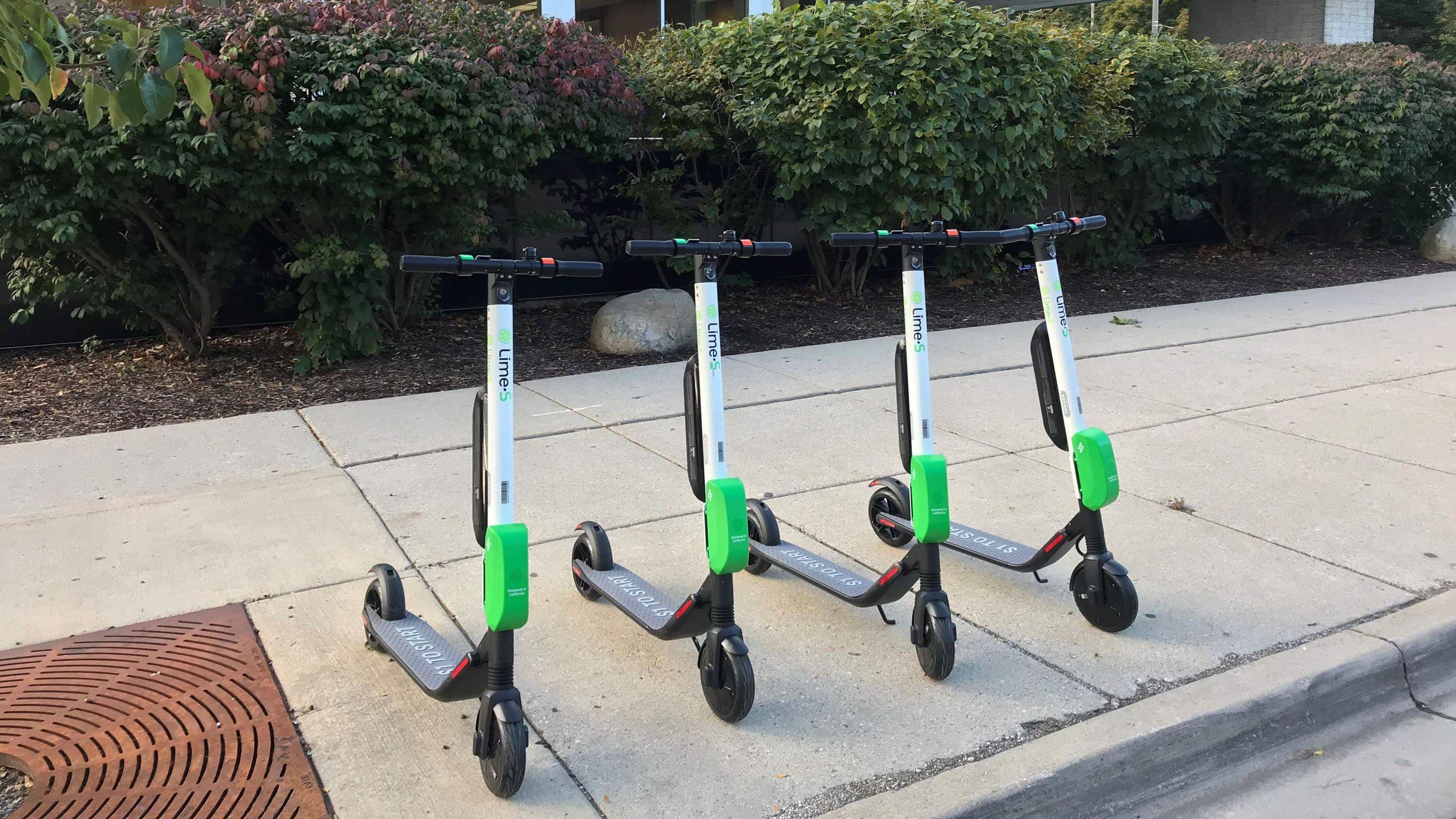 Lime scooters lined up on sidewalk