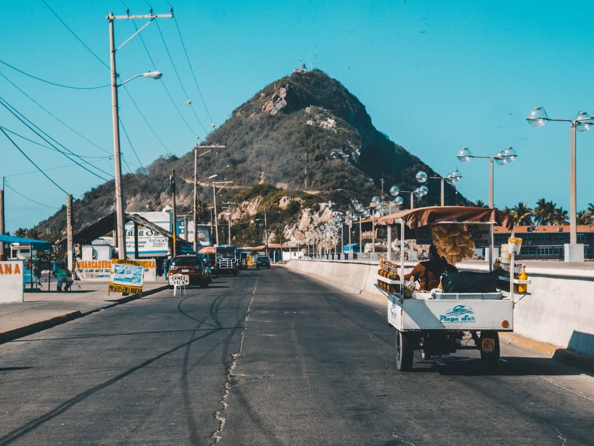 Empty street in Mexico with powerlines and a hill in the background