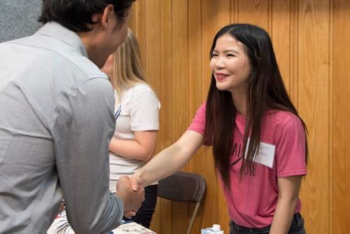 A Career Fair attendee shaking hands with a prospective employer