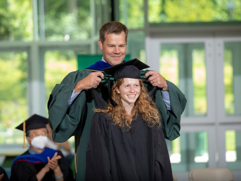 Professor Doug Van Citters hoods Alison Anderson, who earned her bachelor of engineering from Thayer in 2020.
