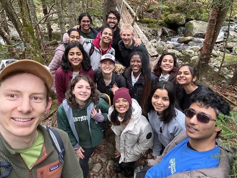 A group of students smile for the camera in the woods of Mt. Moosilauke.
