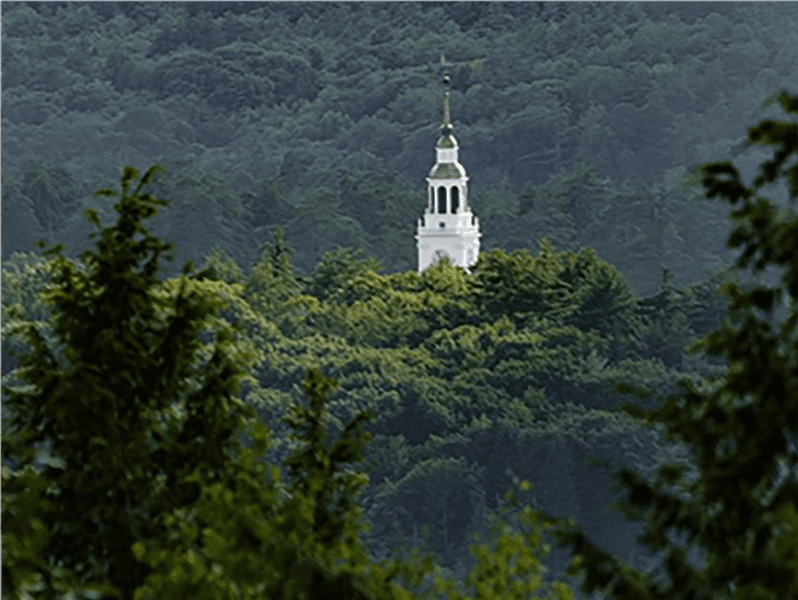 The Dartmouth tower can be seen poking above the green trees.