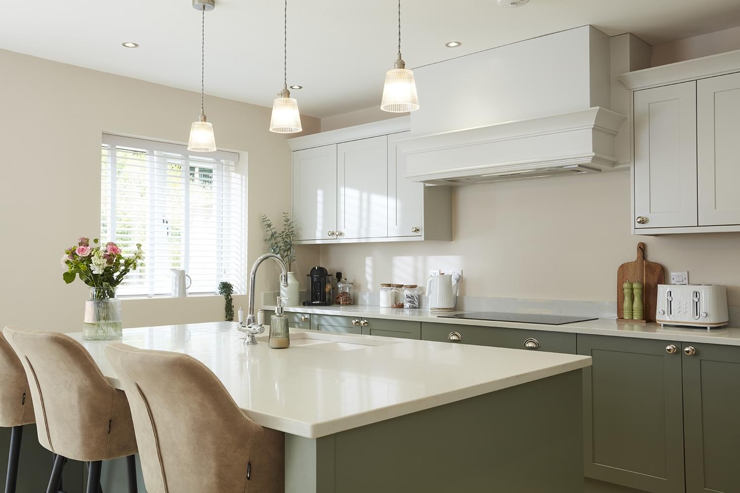 White quartz worktops with green cabinetry