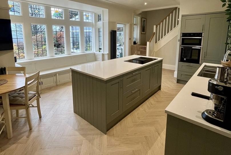 Green Kitchen Island and cabinets with white quartz countertops