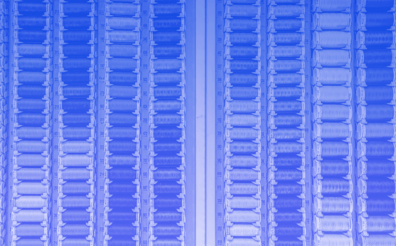 Image shows wall of thread with a blue filter.