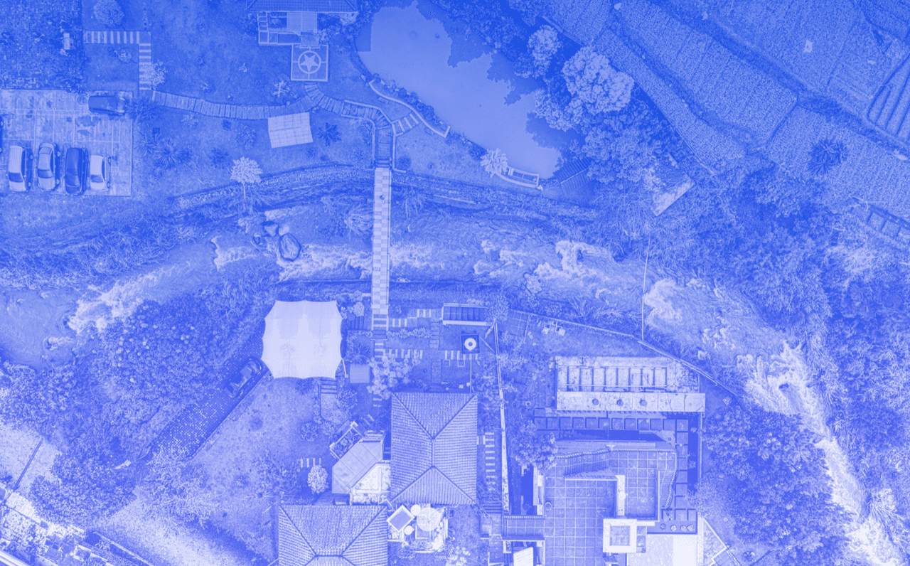 Image shows a factory from a bird's eye view with a blue filter.