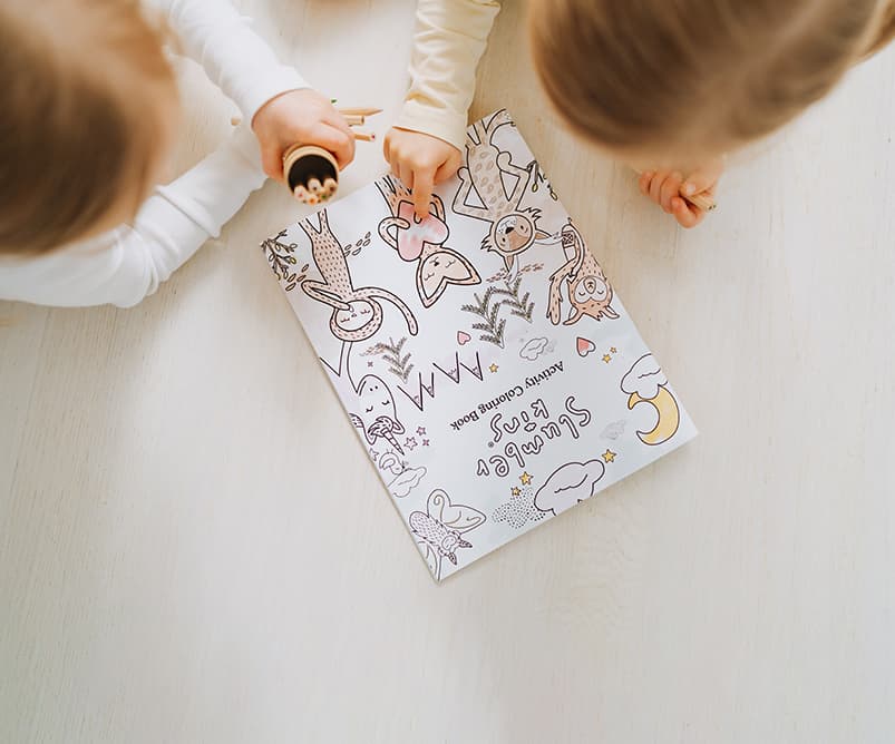 Children coloring a Slumberkins coloring page