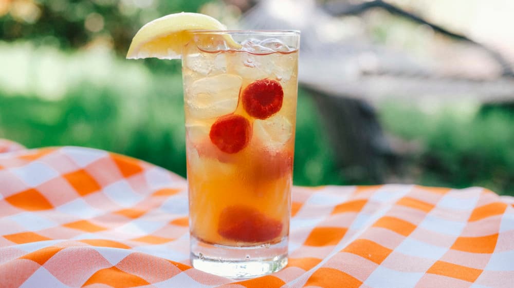 Tito's Vodka raspberry lemonade and tea cocktail on picnic blanket