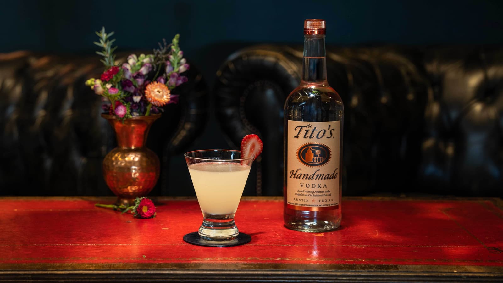 Tito's Cello-Tini on a table with a Tito's Handmade Vodka bottle and flowers
