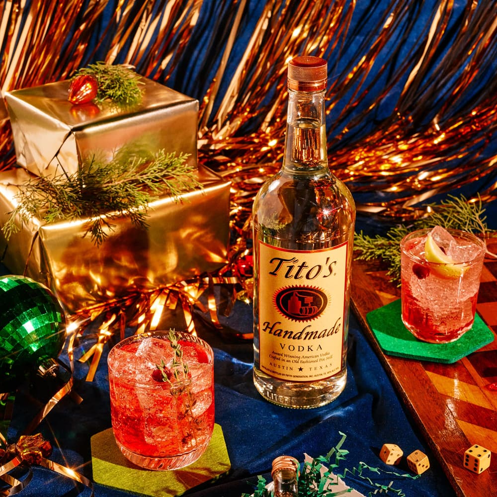Tito's Handmade Vodka bottle and Tito's Holiday Thyme cocktail with holiday decorations
