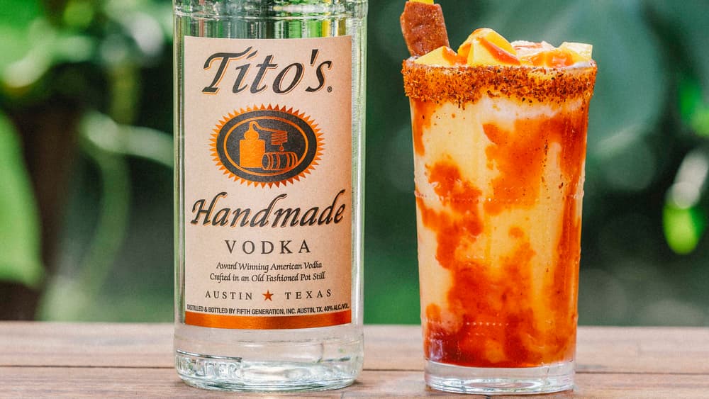 Tito's Mangonada cocktail next to a Tito's Vodka bottle