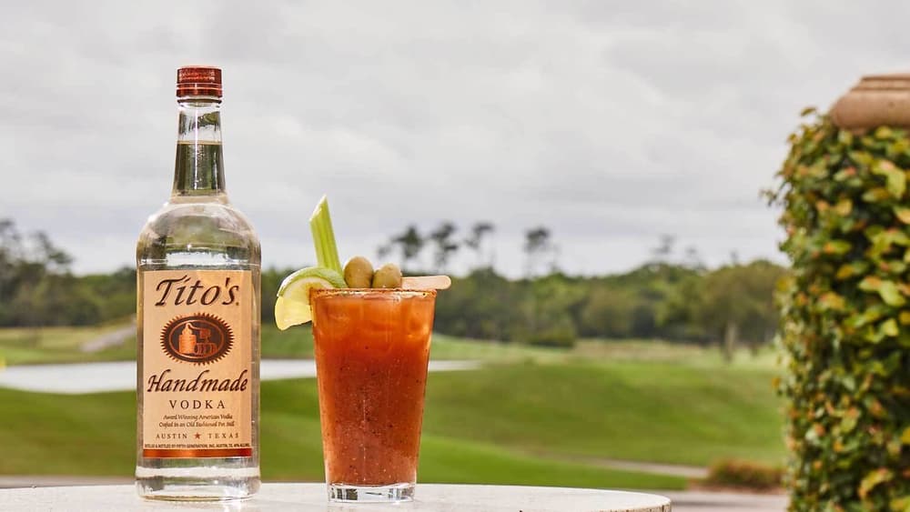 Tito's Mulligan Mary with a bottle of Tito's Handmade Vodka on a golf course