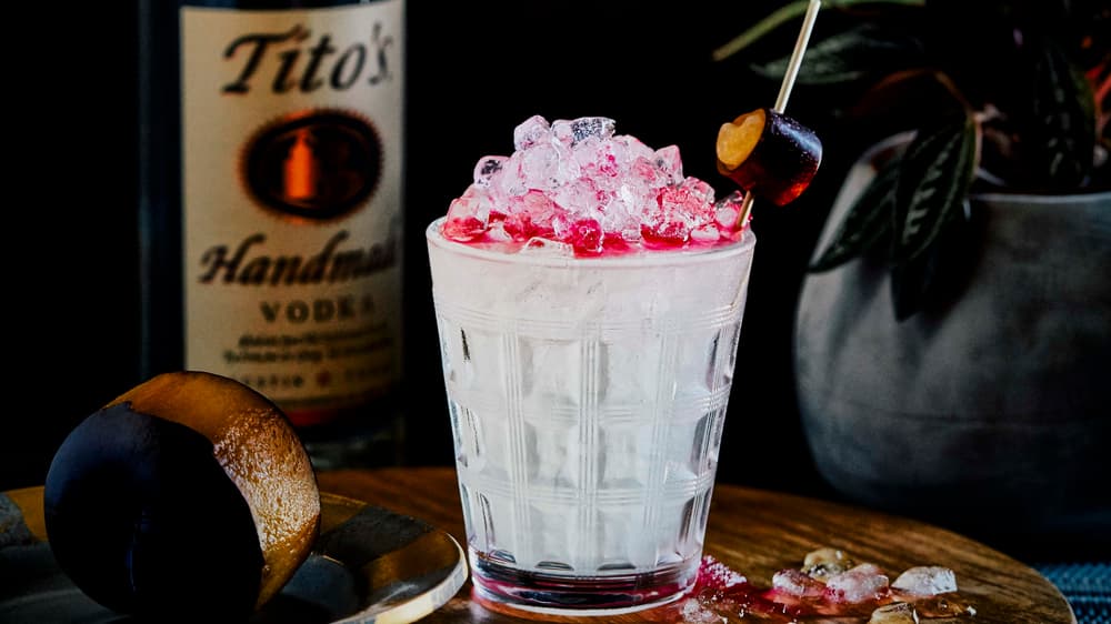 Tito's Peach Plum Mule in a glass garnished with a plum peel