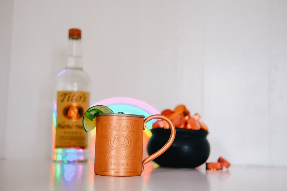 Tito's Copper Mug in between a Tito's Vodka bottle and a pot of candy