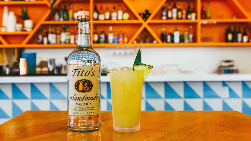 Tito's Sparkling Guava at a bar next to a Tito's Handmade Vodka bottle