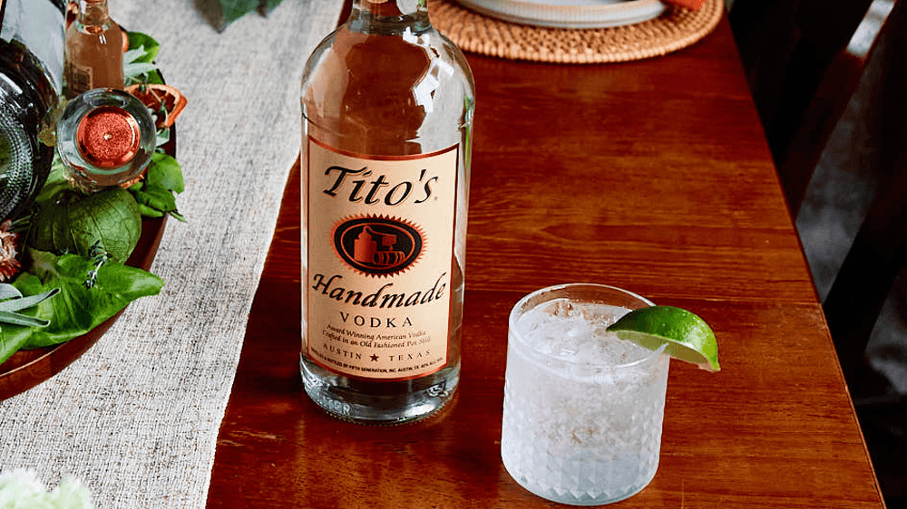 Tito's Soda Lime cocktail and Tito's Handmade Vodka bottle on dining room table