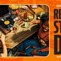Friends sitting around a table with a vinyl record playing and drinking cocktails. Record Store Day, April 20th, 2024.