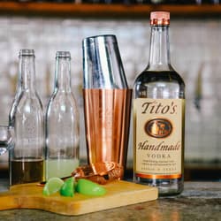 Tito's bottle with shaker set and gimlet ingredients