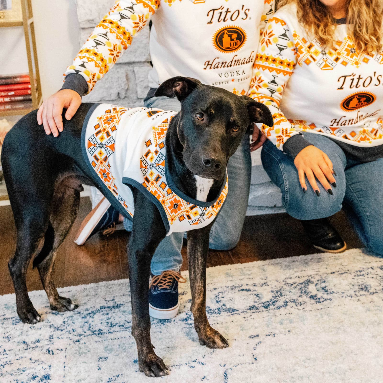 A dog and his humans in Tito's Uglyish Sweaters