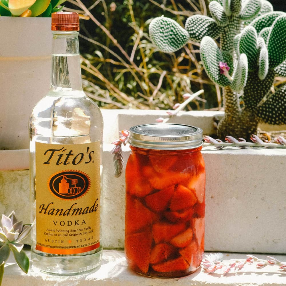Tito's Strawberry Infusion next to a Tito's Vodka bottle
