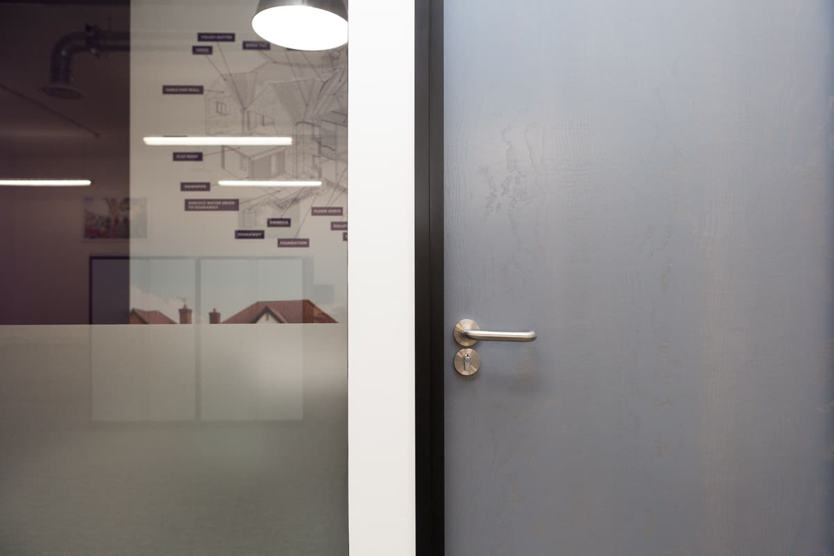 Closed door to office with office visible through glass