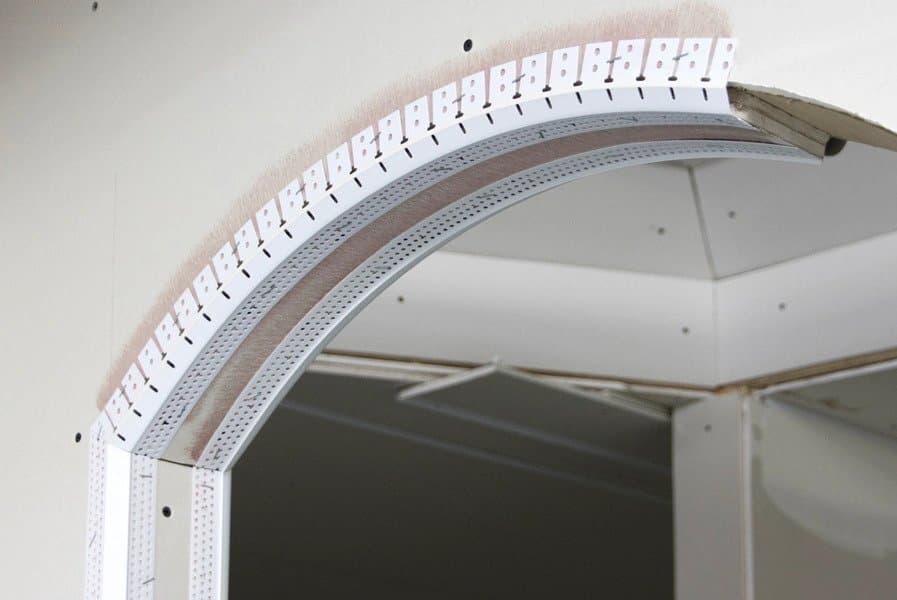 An archway with vinyl corner beads being installed.