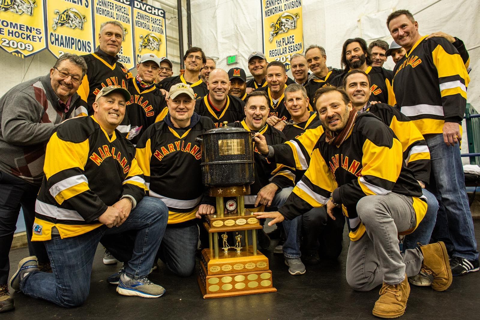 Members of the 1991-92 UMD Men's Club Hockey Team pose with trophy at the 30th anniversary of their win at the Crab Pot Tournament.