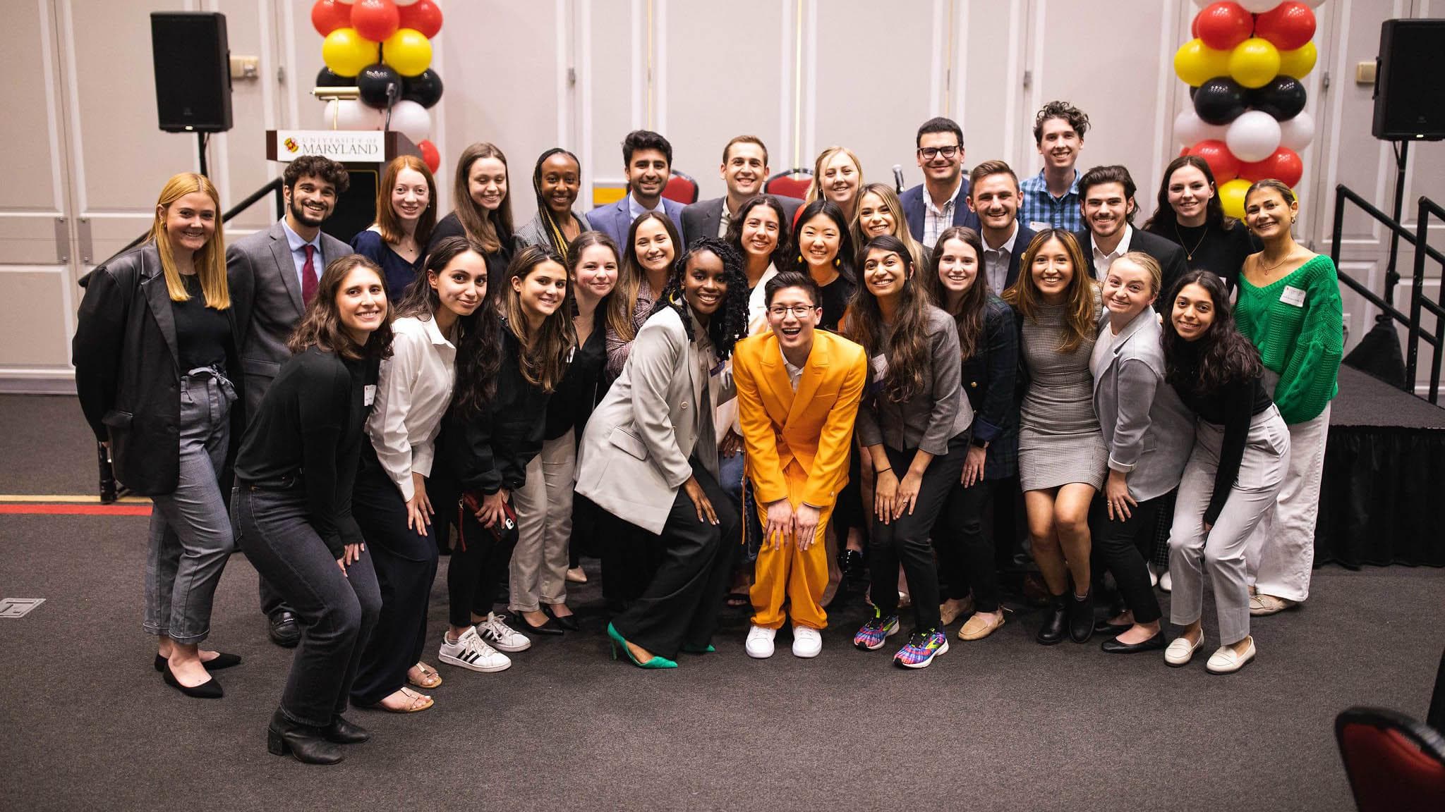 A group consisting of young alums and current students pose with the Terps Under 30 2022 event speakers