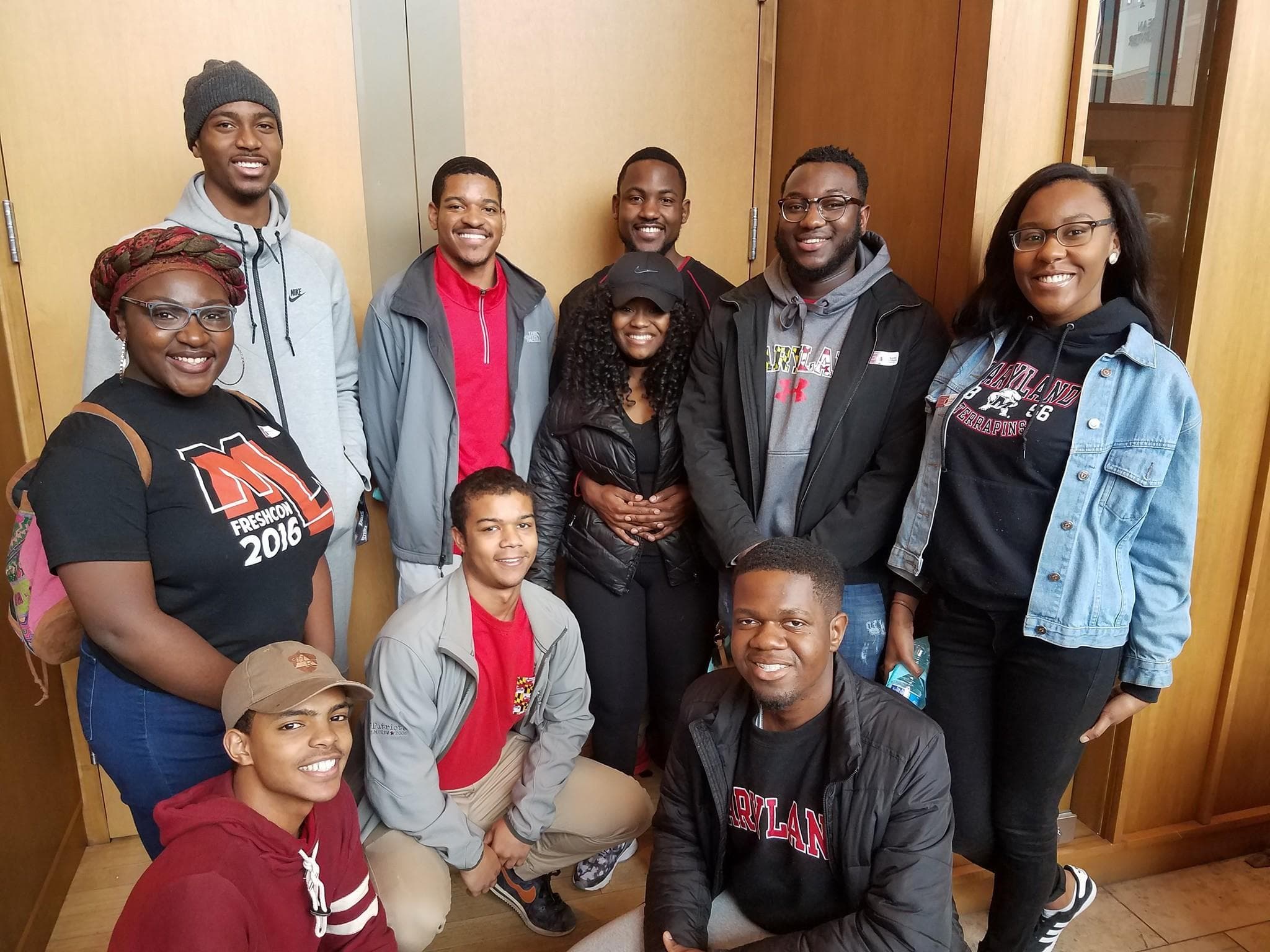 A group of students posing in front of a room.