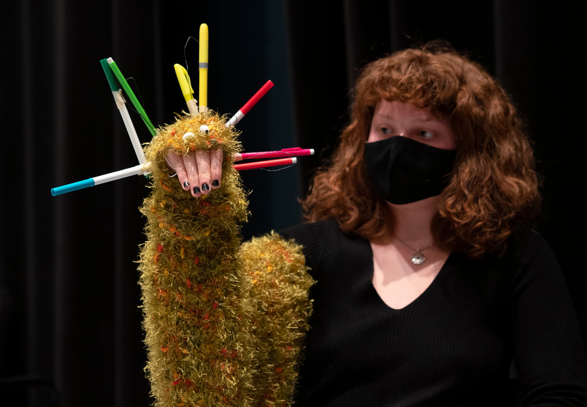 A woman performs with a hand puppet.