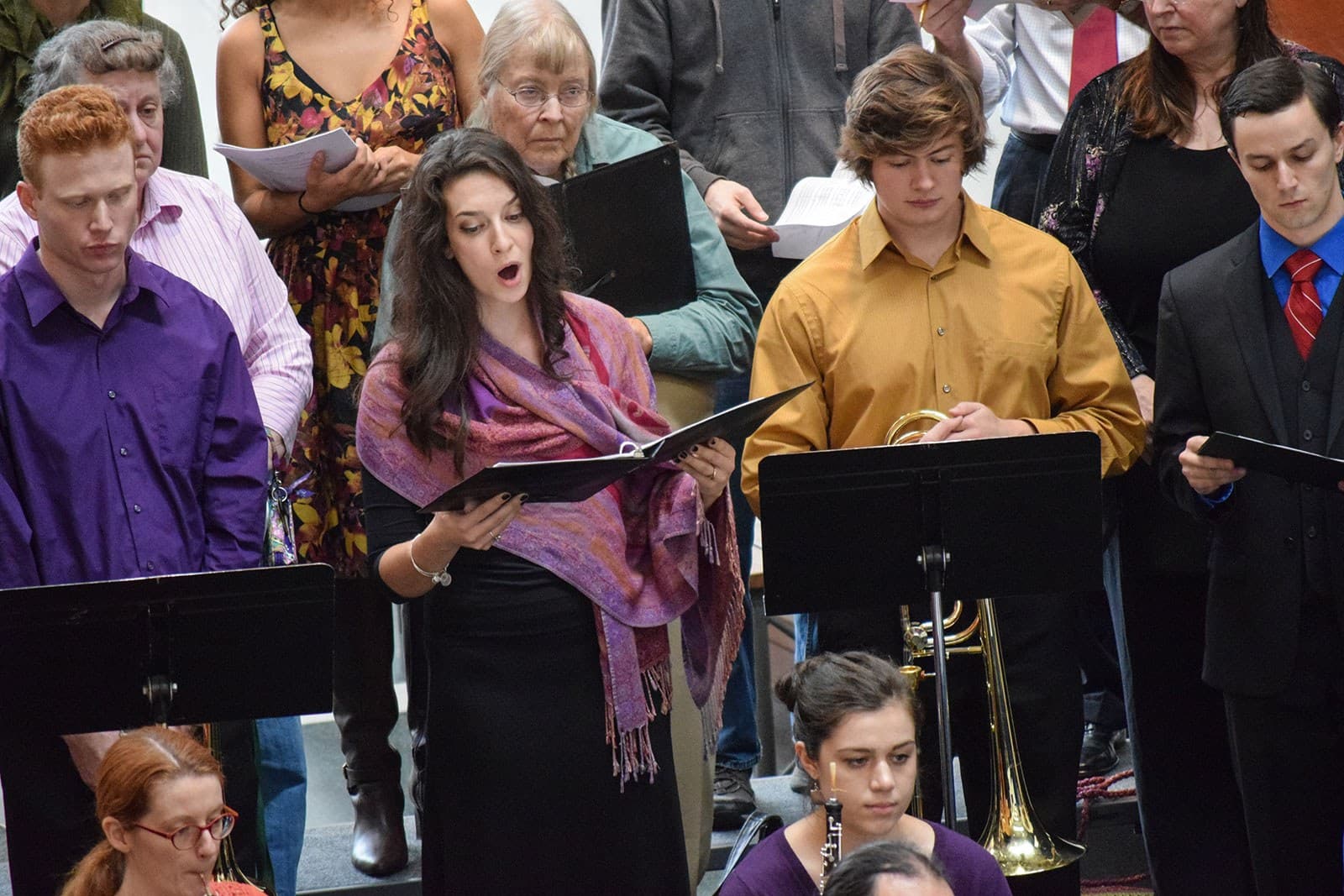 Men and women of various ages sing.