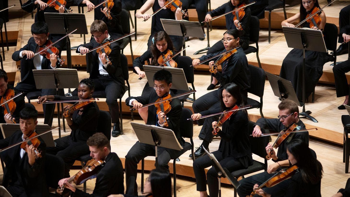 UMD Symphony Orchestra students perform on stage.