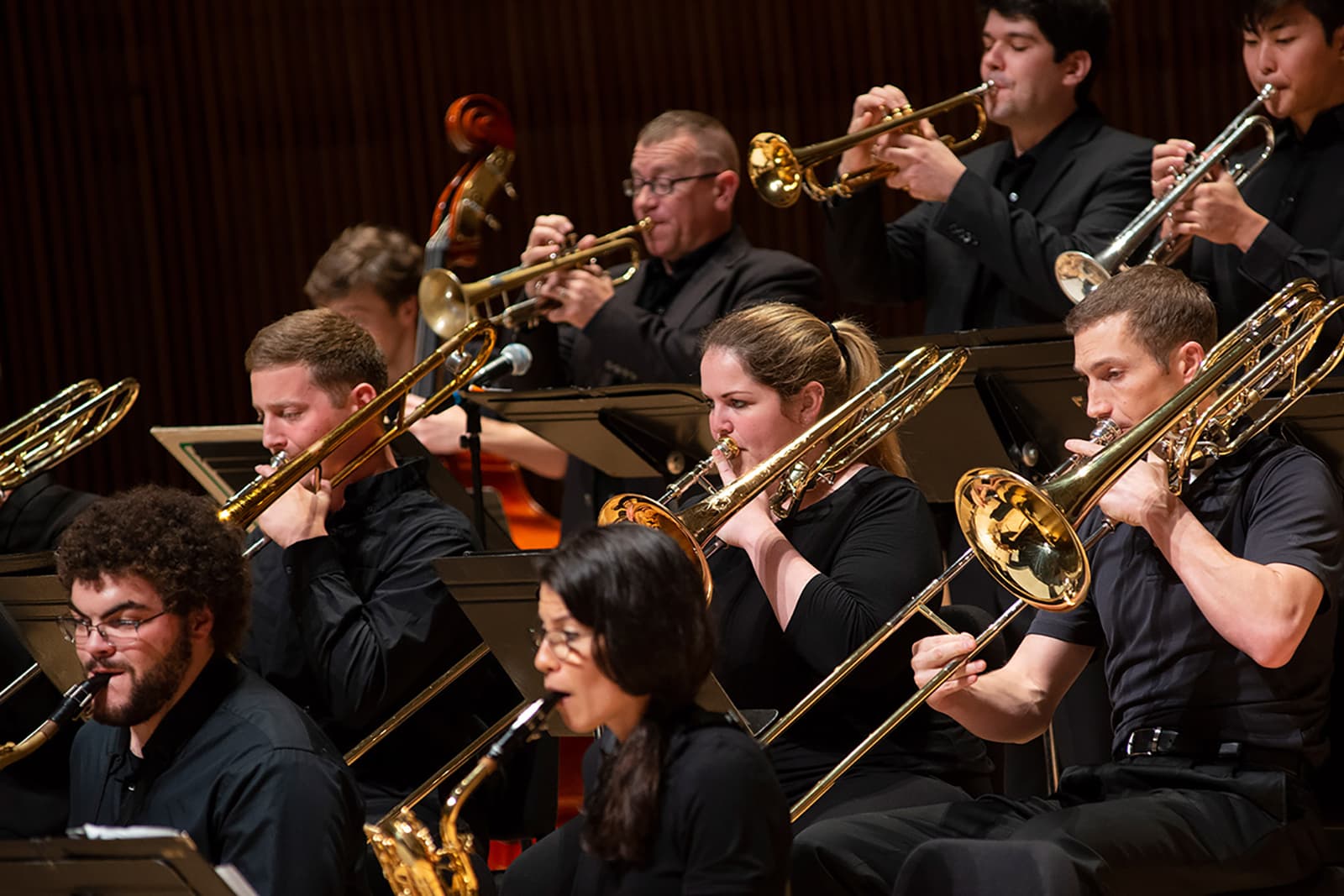 Students play trombones during a performance.
