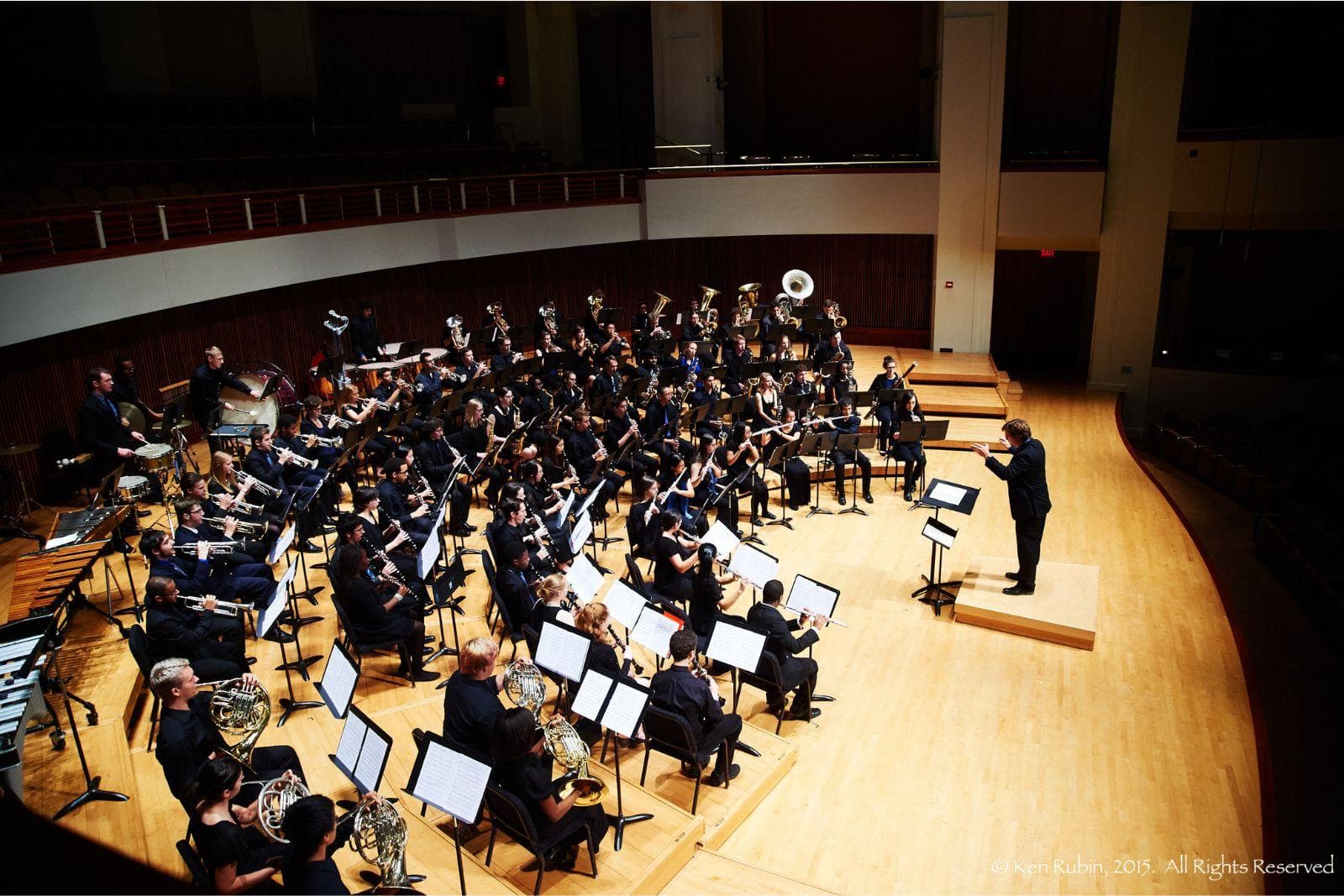 Band members perform on stage with an array of brass and wind instruments.